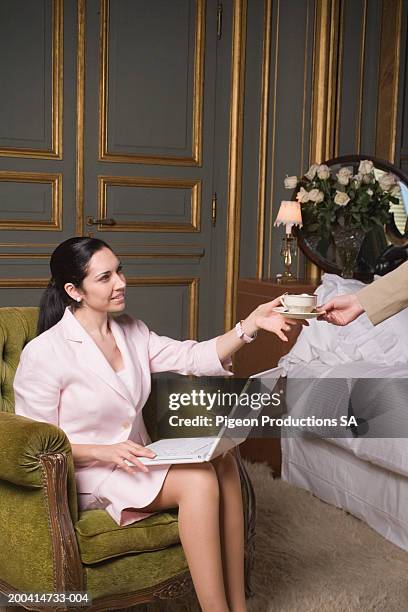 woman sitting on chair with laptop and holding cup - palacio sans souci stock pictures, royalty-free photos & images