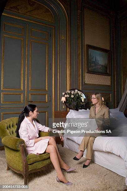 women on chair and bed with laptop talking - palacio sans souci stock pictures, royalty-free photos & images
