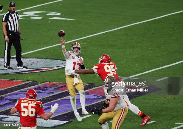 Brock Purdy of the San Francisco 49ers throws a pass while pressured by Chris Jones of the Kansas City Chiefs in overtime during Super Bowl LVIII at...