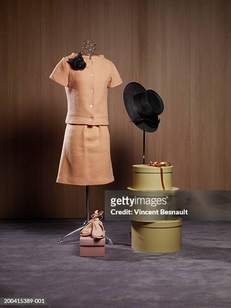 dress on dressmaker's model by hat boxes and shoes - mannequin stockfoto's en -beelden