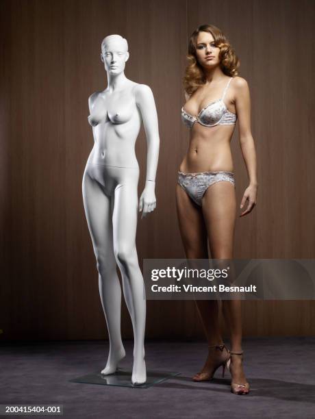 young woman in underwear by mannequin, portrait - mannequin stockfoto's en -beelden