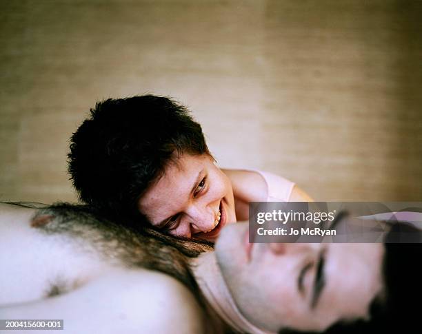 young woman lying on man's chest, close up - female hairy chest stock-fotos und bilder