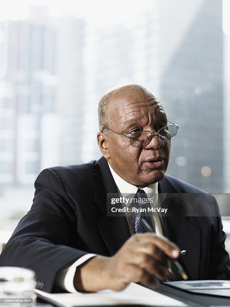 Mature businessman sitting at conference room table