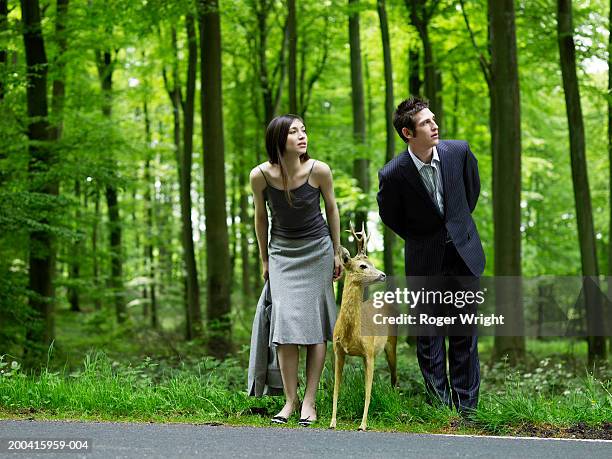 businessman, woman and stuffed deer looking down country road - lyons la forêt photos et images de collection