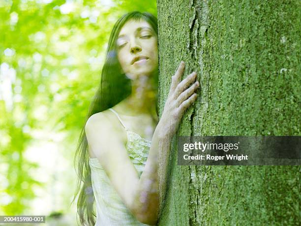 woman embracing tree, eyes closed (digital composite) - lyons la forêt photos et images de collection