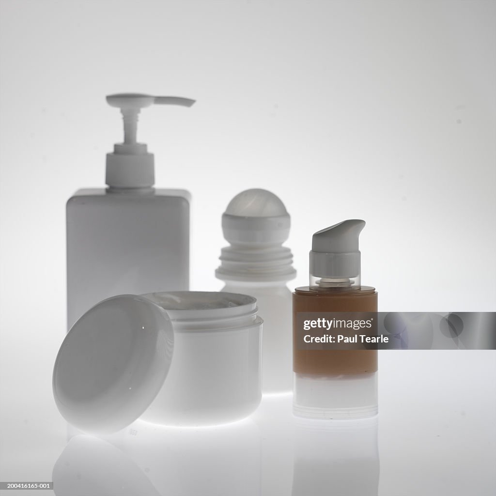 Bottle of make-up, deodorant, soap dispenser, moisturiser tub close up