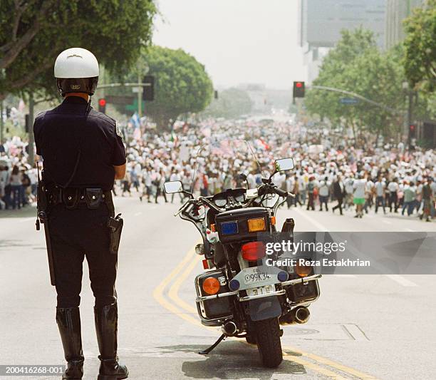 police in front of crowd for immigration bill rally in los angeles - may day protest in los angeles photos et images de collection