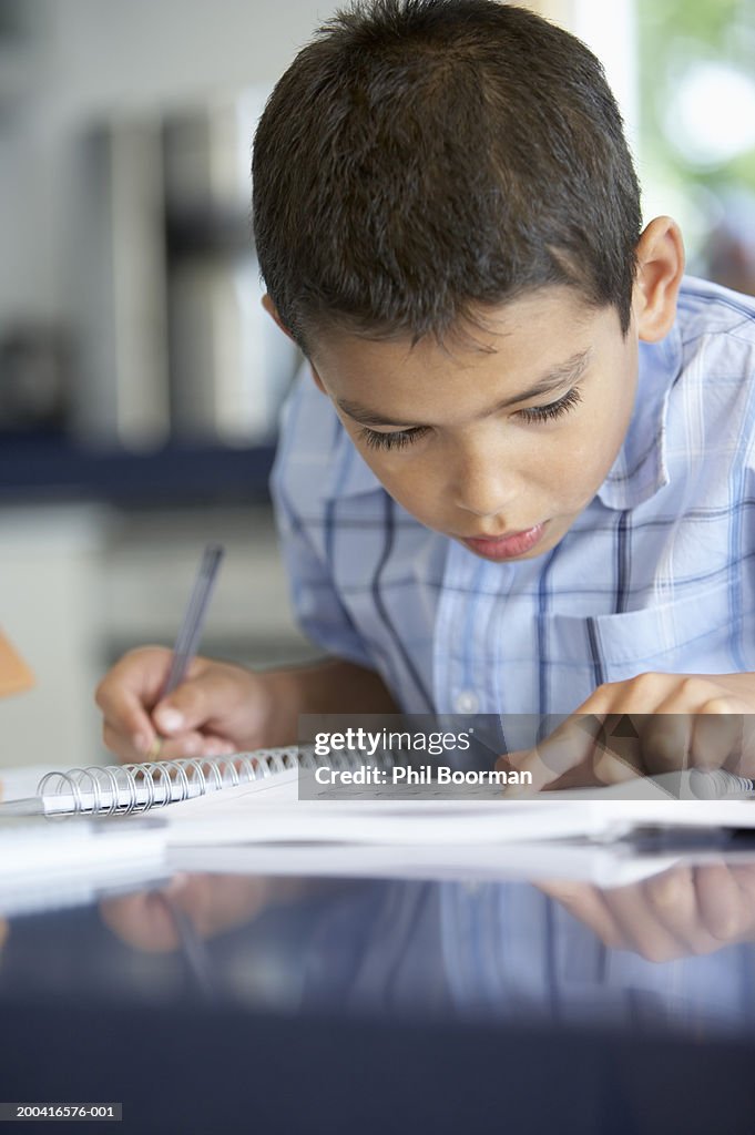 Boy (8-10) doing homework, close-up
