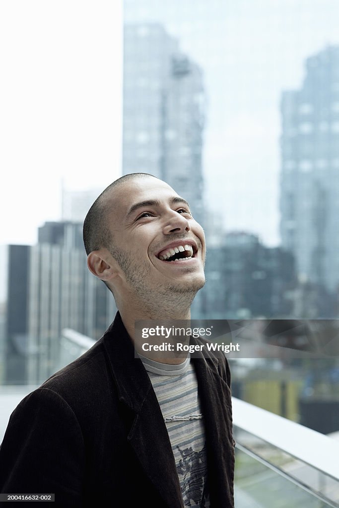 Young man laughing, head back, close-up