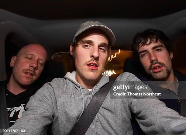 three young men riding in car, night, portrait - back seat stock pictures, royalty-free photos & images