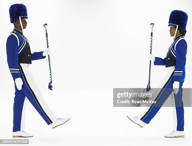 two drum majors holding batons, marching toward one another, side view - majorette stock pictures, royalty-free photos & images