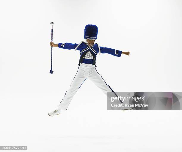 drum majorette with baton jumping in midair, blowing whistle - majorette stock pictures, royalty-free photos & images