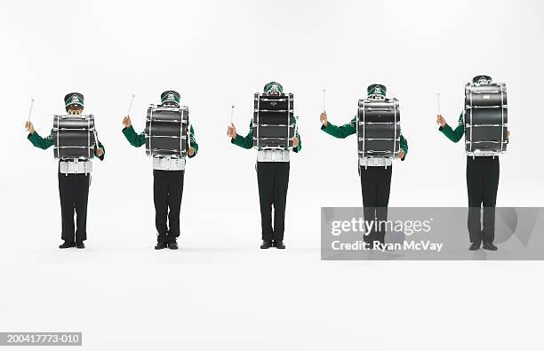 five teenagers (14-18) in marching band uniforms playing bass drums - bass drum stock-fotos und bilder