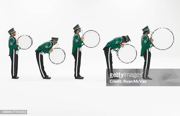 five teenagers (14-18) in band uniforms carrying bass drums, side view - bass drum stockfoto's en -beelden