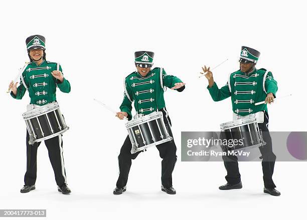 three teenage boys (14-17) in marching band uniforms playing drums - musician foto e immagini stock