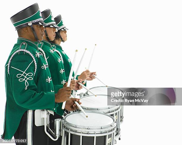 three teenage boys (14-17) in band uniforms carrying drums, side view - drums white background stock pictures, royalty-free photos & images