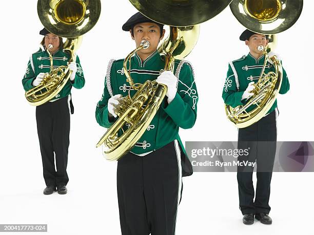 three teenage boys (16-18) in marching band uniforms playing tubas - marching band stock pictures, royalty-free photos & images