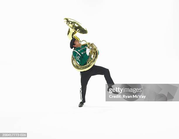 teenage boy (16-18) in marching band uniform playing tuba, eyes closed - banda de marcha fotografías e imágenes de stock