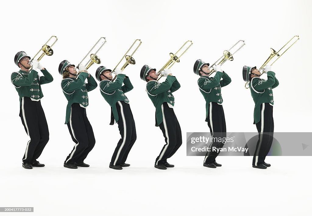 Six teenagers (15-17) in marching band uniforms playing trombones
