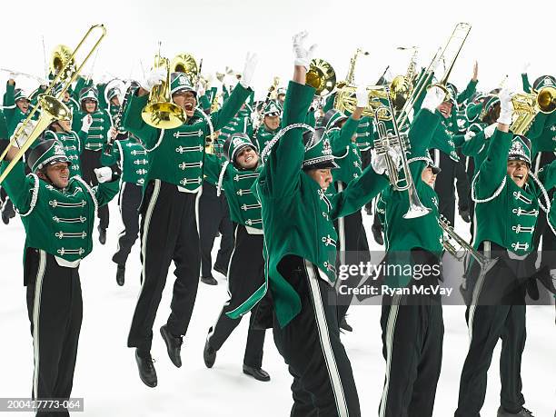 teenage (14-18) marching band jumping and cheering, arms raised - banda de marcha fotografías e imágenes de stock