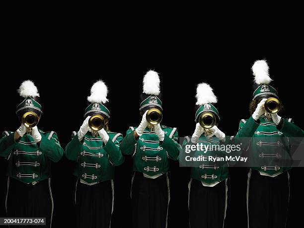 five teenagers (14-18) in marching band uniforms playing trumpets - banda de marcha fotografías e imágenes de stock