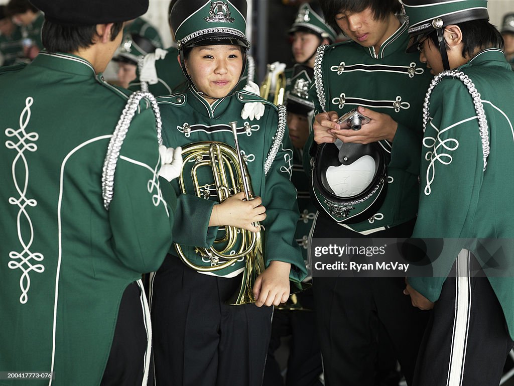 Teenage (14-18) marching band (focus on girl holding wind instrument)