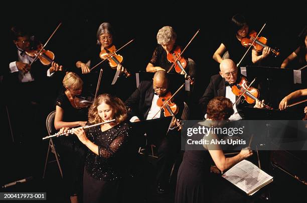 mature woman performing flute solo with orchestra, overhead view - orchestra conductor foto e immagini stock
