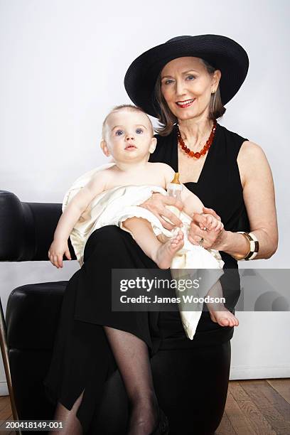 grandmother holding grandson (9-12 months) on lap, portrait - glamourous granny stock pictures, royalty-free photos & images