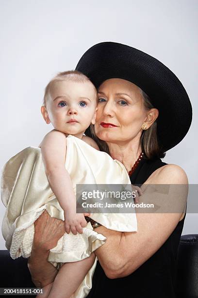 grandmother holding grandson (9-12 months), portrait, close-up - glamourous granny stockfoto's en -beelden
