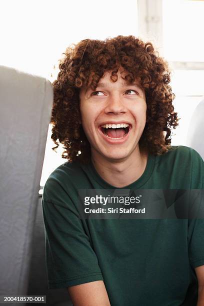 teenage boy (14-16) riding on school bus, smiling, looking up - boy with long hair stock pictures, royalty-free photos & images