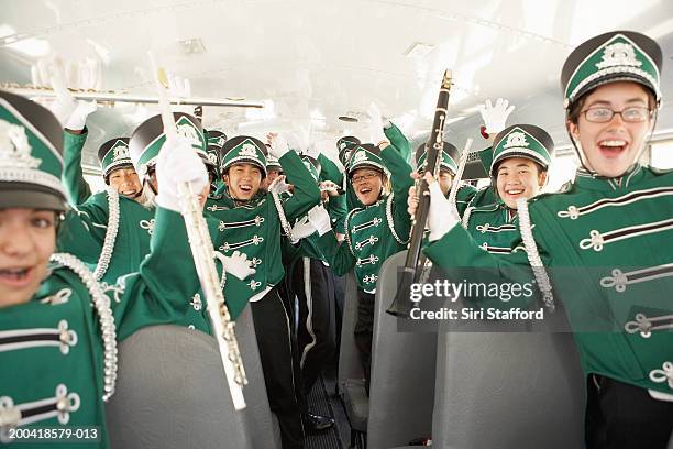 teenage (14-18) marching band cheering and shouting on school bus - passenger muzikant stockfoto's en -beelden