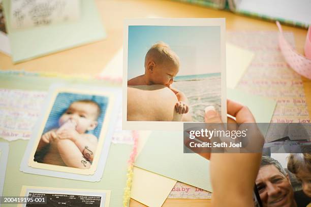 woman holding baby picture for scrapbook - one young woman only photos 個照片及圖片檔