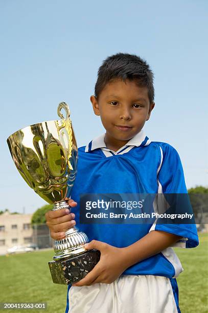 boy (7-9) holding trophy, portrait, low angle view - title nine imagens e fotografias de stock