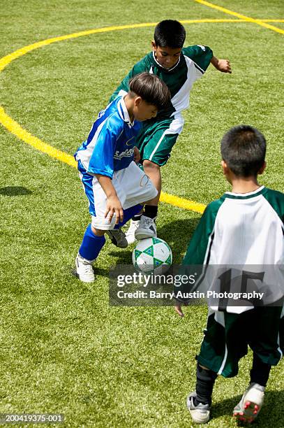 boys (7-9) playing football - kids' soccer stock pictures, royalty-free photos & images