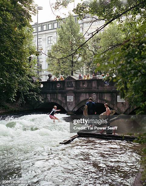 germany, munich, englischer garden, surfer riding eisbach river wave - munich surfing stock pictures, royalty-free photos & images