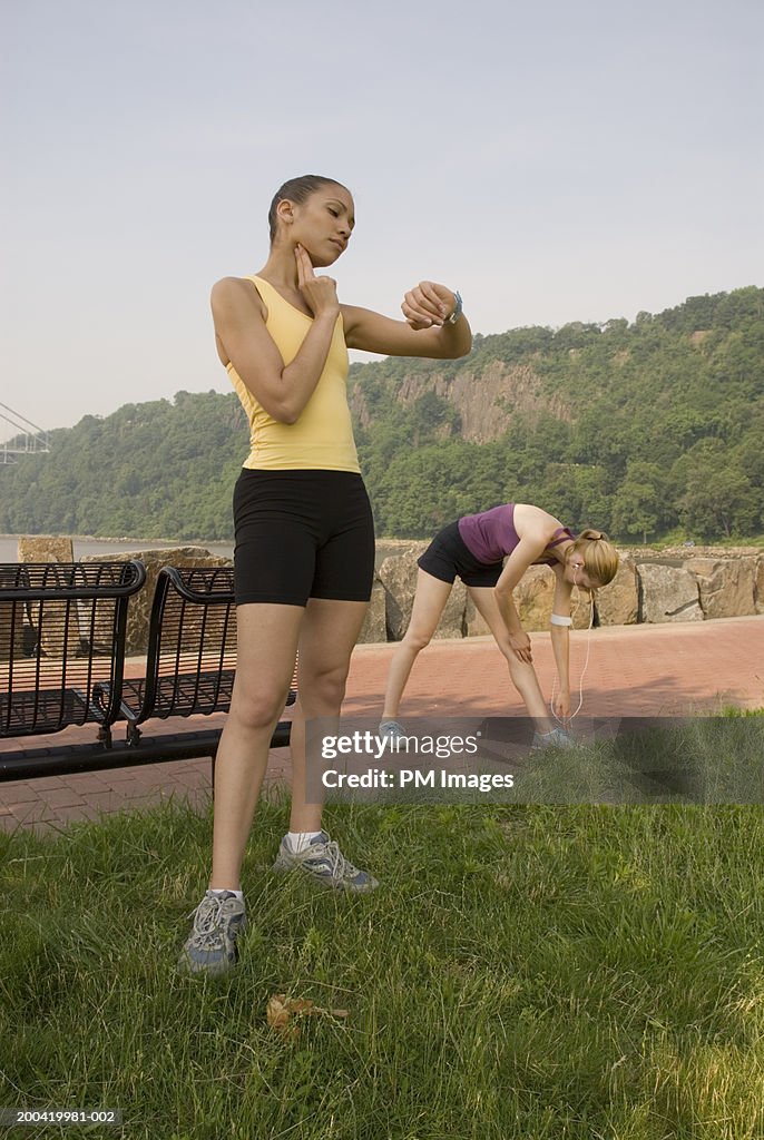 Two women checking pulse and stretching