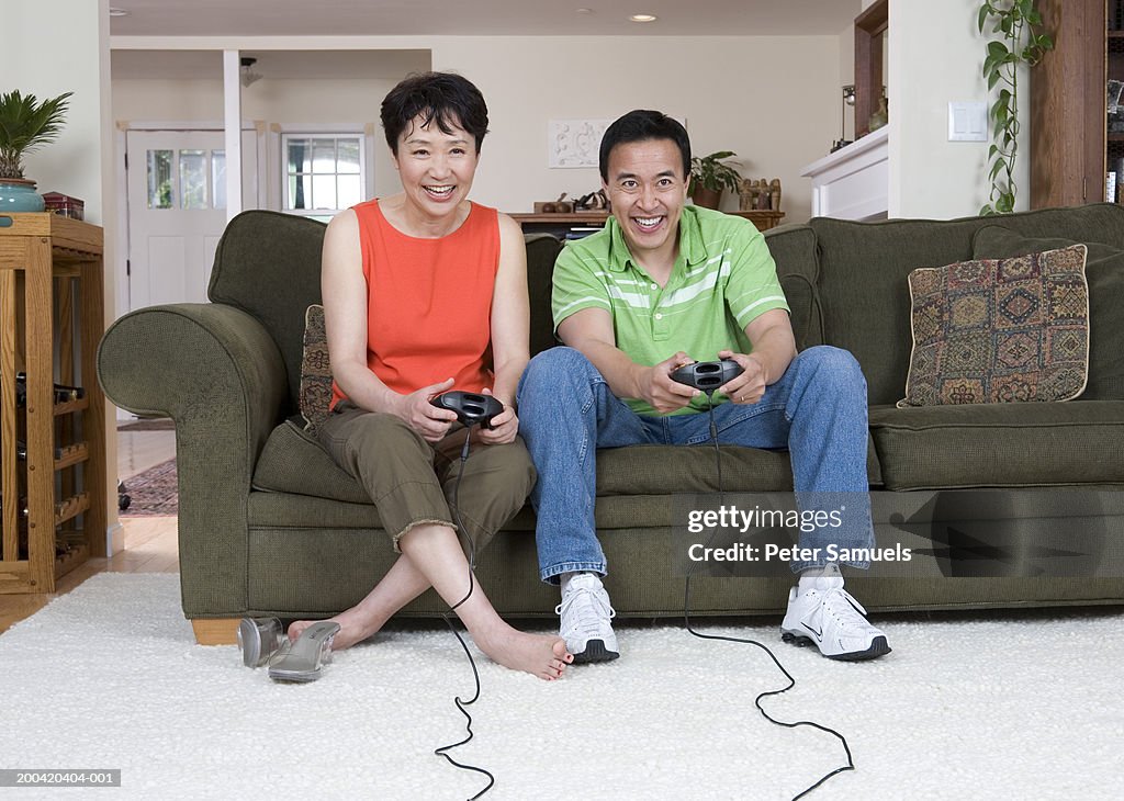 Couple playing video game in living room