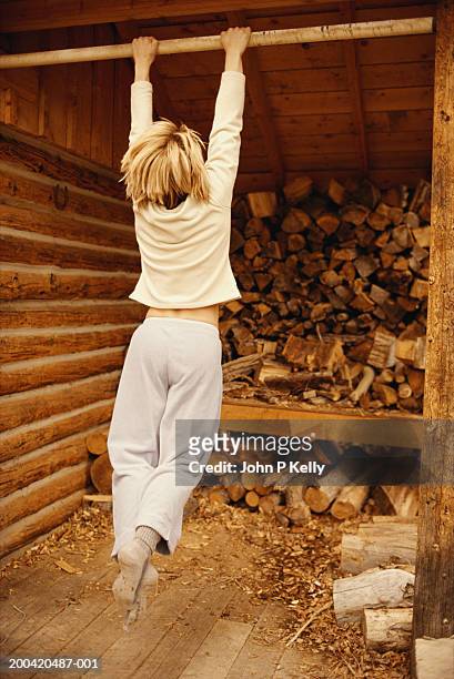 woman swinging from cross beam in woodshed, rear view - east elk creek stock pictures, royalty-free photos & images