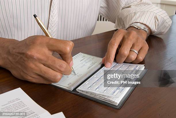man at desk writing check, close-up - cheque stock pictures, royalty-free photos & images