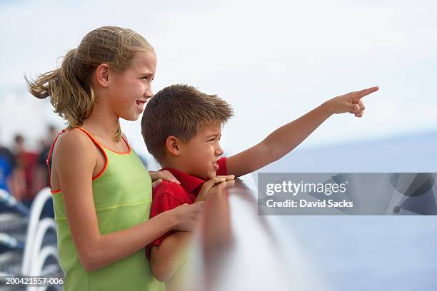 brother and sister (10-12) on cruise ship, boy pointing - railings stock pictures, royalty-free photos & images