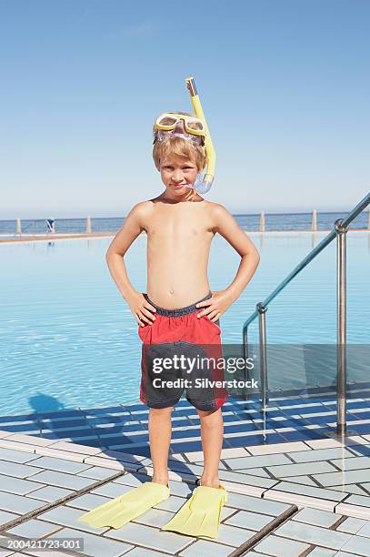 boy (6-8) in snorkel gear by outdoor pool, hands on hips, portrait - swimwear stock pictures, royalty-free photos & images