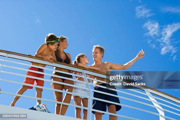 parents with children (10-12) talking near rail on cruise ship - cruise deck stock pictures, royalty-free photos & images