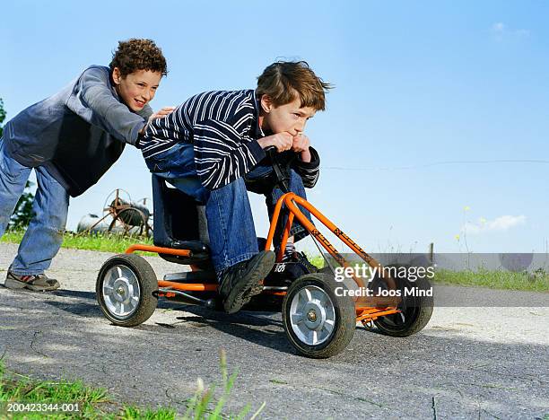 boys (8-10) playing with go-cart, outdoors - soapbox cart stock pictures, royalty-free photos & images