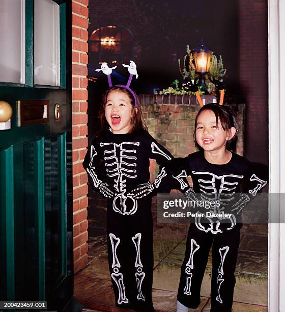 two girls (4-6) wearing skeleton costumes, smiling, portrait - trick or treat stock pictures, royalty-free photos & images