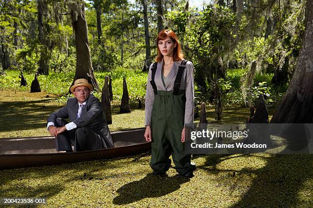 businessman and woman in swamp, man in canoe, portrait - sumpf stock-fotos und bilder