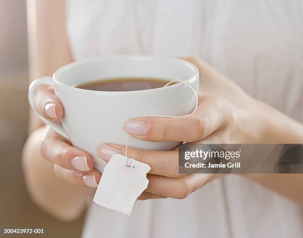 woman holding cup of tea, close-up - sachet de thé photos et images de collection