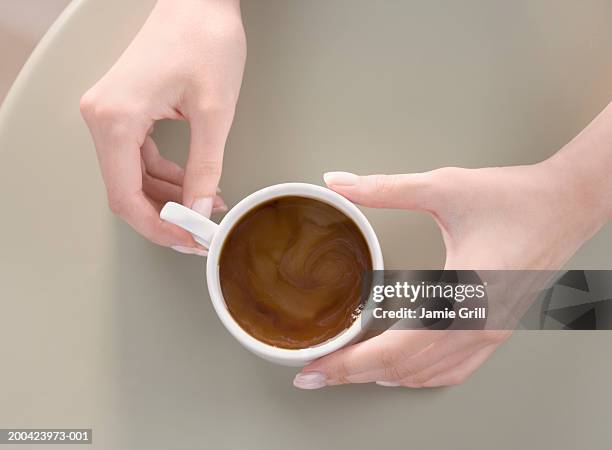 woman holding coffee cup on table, close-up, overhead view - café vu de haut photos et images de collection