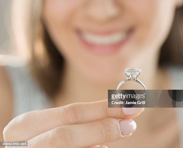 woman holding engagement ring, close-up (focus on ring) - finger ring stock pictures, royalty-free photos & images