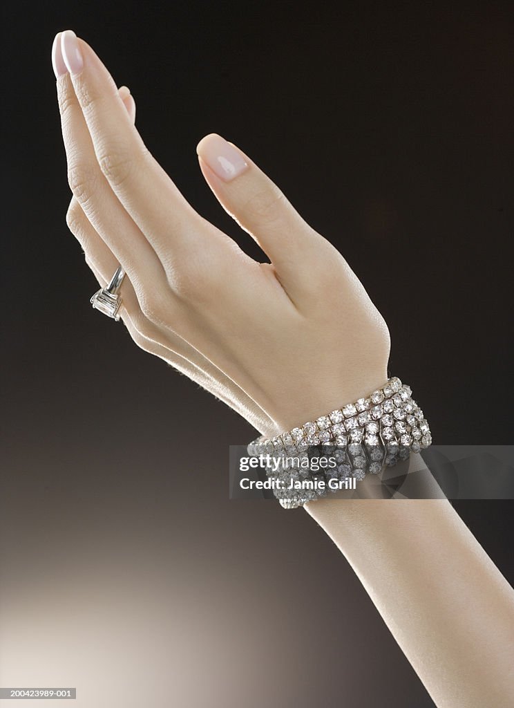 Woman wearing diamond ring and bracelets, close-up