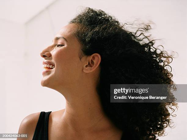 young woman smiling, close up, side view - curly black hair stock pictures, royalty-free photos & images